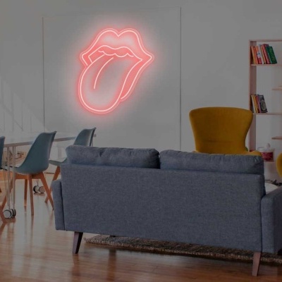 Sala com sofá cinza, poltronas amarelas, mesa com cadeiras e letreiro de néon em forma de boca