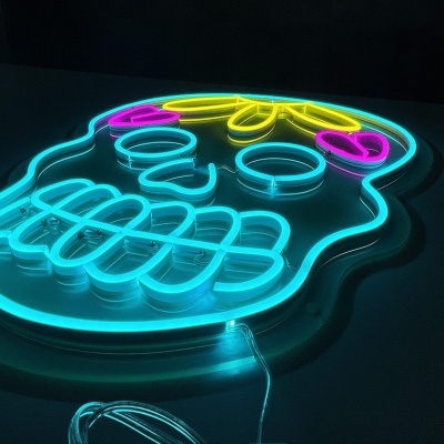 Neon em forma de caveira colorida com luzes azul, amarelo e rosa