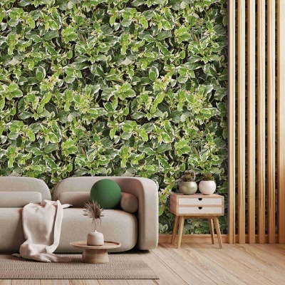 Papel de parede folhoso verde e branco numa sala com sofá bege, mesa baixa e mesa de cabeceira de madeira.