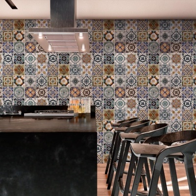 Cozinha moderna com ilha preta, bancos de madeira escura e azulejos coloridos na parede