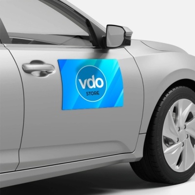 Adesivo azul com texto 'vdo STORE' na porta de carro cinzento