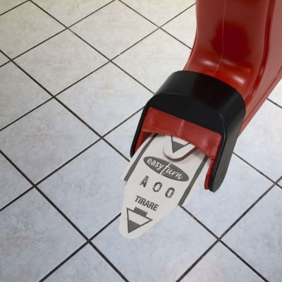 Prancha de skate vermelha com texto no shape sobre chão de azulejos