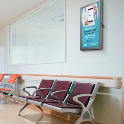 Cadeiras de espera coloridas em espaço hospitalar com quadro informativo na parede