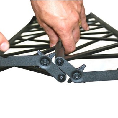 Estrutura preta de plástico com design em treliça sendo segurada por mãos humanas