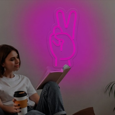 Jovem a ler num sofá com luz neon rosa na parede