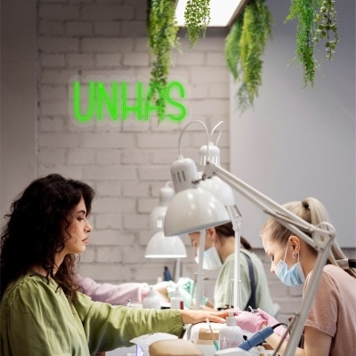 Salão de manicure com placa de néon UNHAS e plantas suspensas