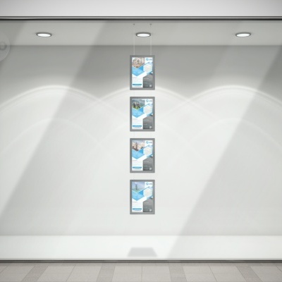 Vitrine de loja com quatro cartazes verticais iluminados em fundo branco