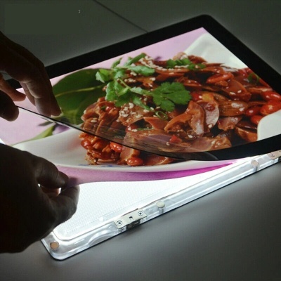 Painel luminoso com imagem de prato alimentar e mãos segurando película transparente