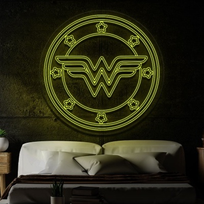 Símbolo da Mulher-Maravilha em neon amarelo numa parede cinza por trás de cama moderna com móveis de madeira