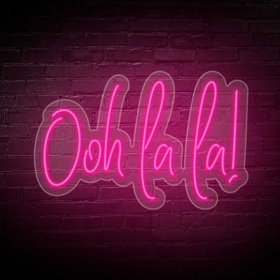 Placa de neon rosa com texto Ooh la la! numa parede de tijolos roxa