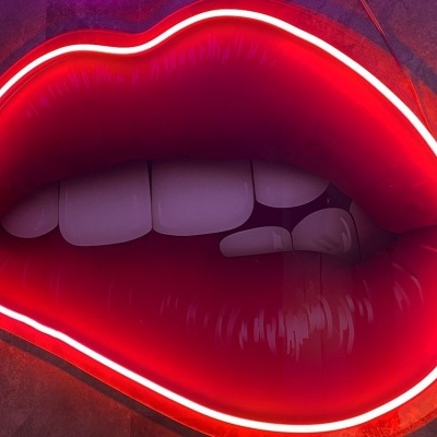 Letreiro de boca vermelha iluminado por néon com dentes brancos