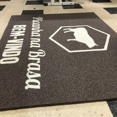 Tapete castanho com texto branco e logotipo de boi para entrada