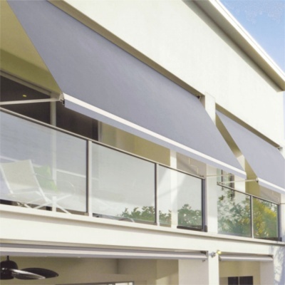 Toldo cinzento escuro numa varanda de casa moderna com guarda-corpos de vidro