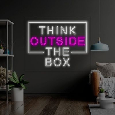 Painel de neon com frase THINK OUTSIDE THE BOX numa sala moderna escura com plantas e sofá