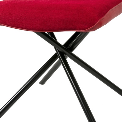 Cadeira com assento vermelho e pernas de metal pretas cruzadas