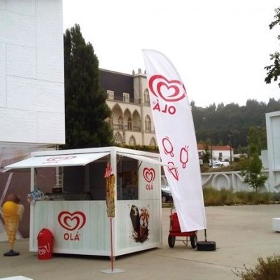 Quiosque de gelados Olá com bandeira e escultura de gelado amarelo ao ar livre