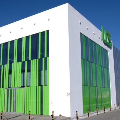 Edifício branco com painéis verticais verdes e letras IBS no topo