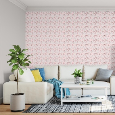 Sala de estar com sofá branco, almofadas coloridas e papel de parede com corações rosa