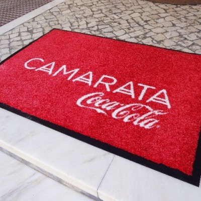 Tapete vermelho com textos Camarata CocaCola