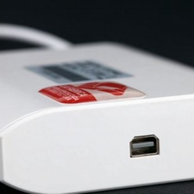 Dispositivo eletrónico com entrada USB e etiqueta vermelha numa superfície preta