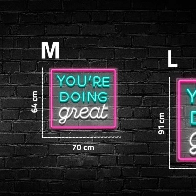 Três quadros com texto em neon com três tamanhos diferentes pendurados em parede preta