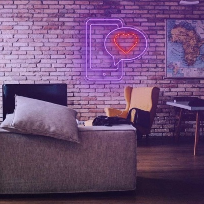 Sala com sofá cinza, cadeira amarela, mesa, mapa da África e luminária de néon.