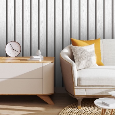 Mesa de cabeceira com relógio e vasos ao lado de sofá com almofadas