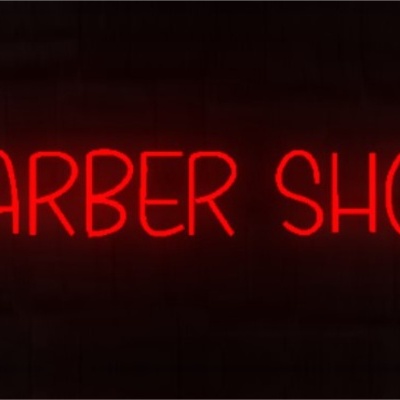 Sinal de néon vermelho BARBER SHOP numa parede escura de tijolos