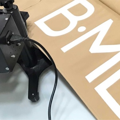 Máquina preta ao lado de placa de cartão com letras B ME