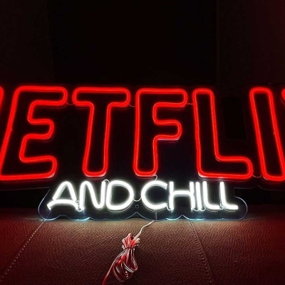 Letreiro de néon com as palavras 'NETFLIX AND CHILL' em vermelho e branco