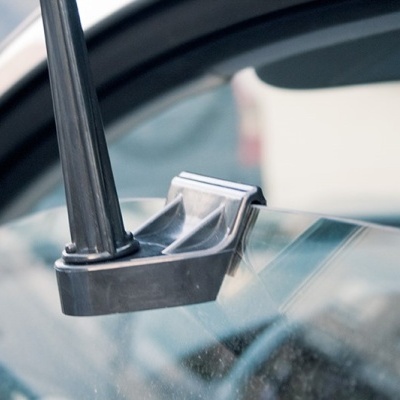 Antena de rádio preta num carro com fundo desfocado