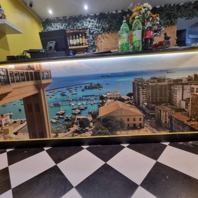 balcão decorado com fotografia panorâmica de cidade costeira e piso xadrez preto e branco