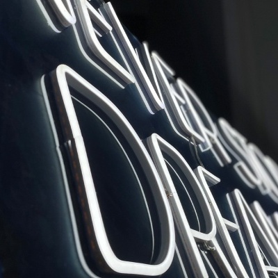 Letreiro néon branco com texto motivacional