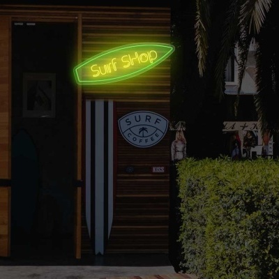 Fachada de loja surf com prancha de surf e letreiro luminoso