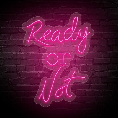Letreiro de néon rosa com 'Ready or Not' numa parede de tijolos