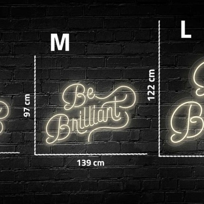 Letreiros em neon 'Be Brilliant' de três tamanhos diferentes, pendurados numa parede de tijolos preta.