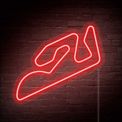 Neon vermelho em forma de circuito de corrida numa parede de tijolos