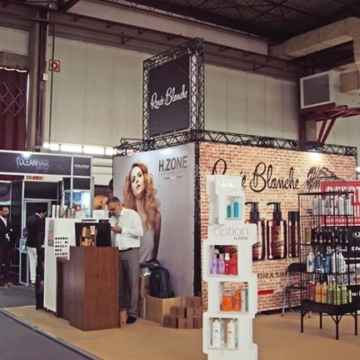 Stand de feira de beleza com painel iluminado e prateleiras de cosméticos