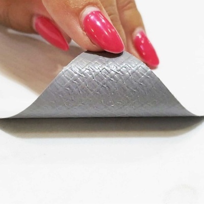 Mão levantando borda de tapete antiderrapante cinzento e branco