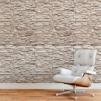 Parede com revestimento que imita pedras e cadeira branca de couro