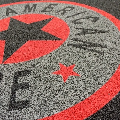 Tapete de entrada com padrão de estrela em vermelho, preto e cinza