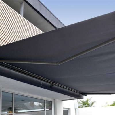 Toldo retrátil cinzento escuro com estrutura metálica preta numa casa moderna cinza