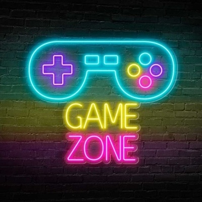 Sinal de néon com comando de videojogos e texto 'GAME ZONE' numa parede de tijolos