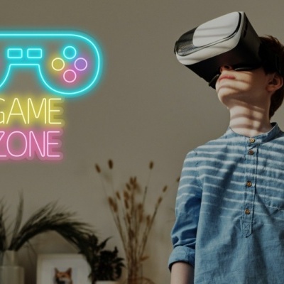 Criança com headset VR e letreiro de néon 'GAME ZONE' na parede