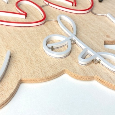 Letreiro decorativo em madeira clara com letras em relevo coloridas