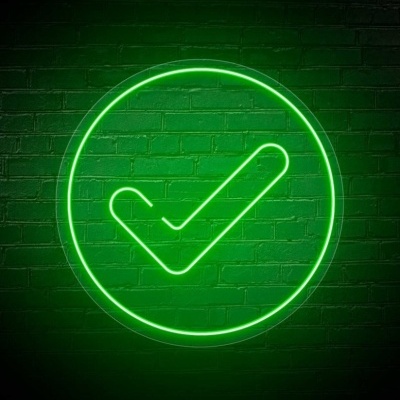 Sinal de visto em néon verde numa parede de tijolo verde