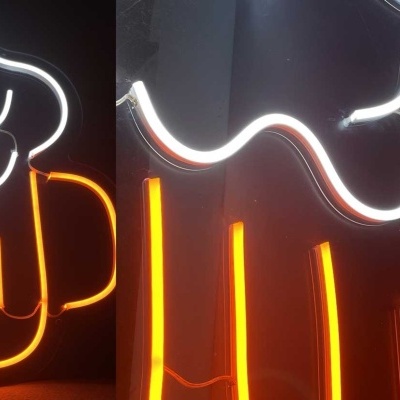 Sinal de néon de um copo de cerveja amarelo com espuma branca