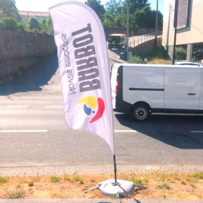 Bandeira publicitária branca com texto BURBOT e logótipo colorido junto a estrada