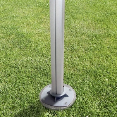 Pé metálico com base redonda numa relva verde