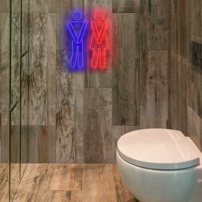 Sanitário branco suspenso em casa de banho com azulejos imitação madeira e sinais luminosos em neon azul e vermelho